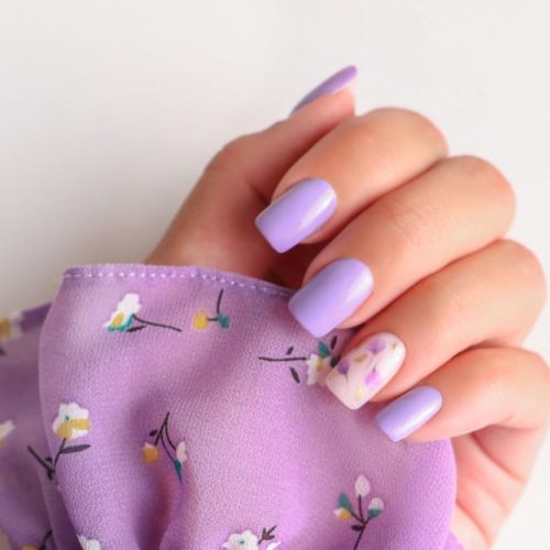 hermosa-mano-femenina-manicura-purpura-diseno-flores